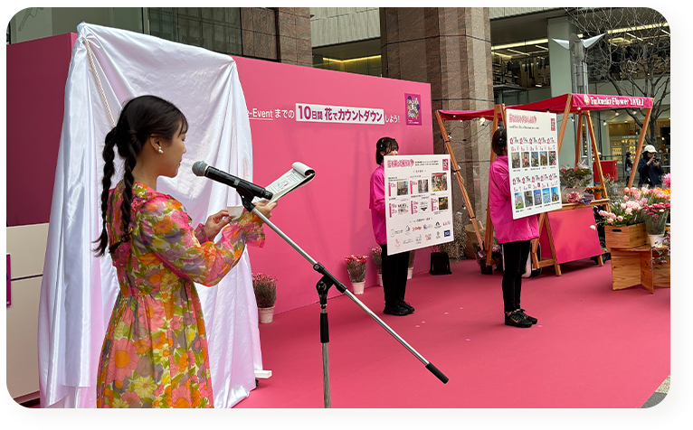 屋外イベントで司会を務める女性タレントの写真