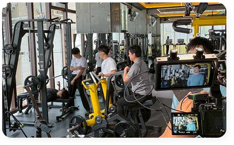 ジムでトレーニング風景を撮影する映像クルーの写真