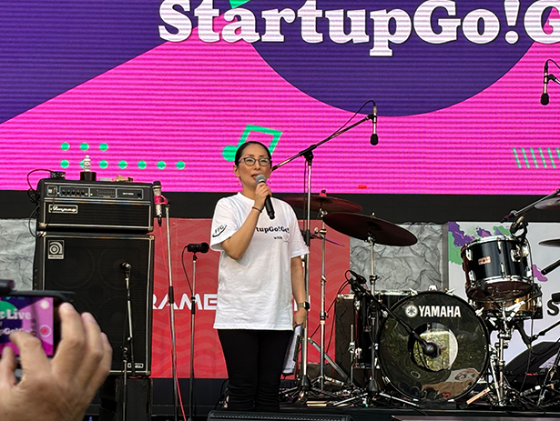 ステージでマイクを持つ司会者